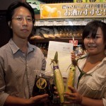 放射能分析表と野菜を手にする同社社員