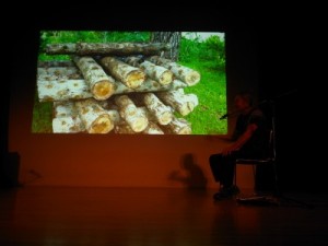 しいたけのホダ木の写真を前に話す儀保さん=7日、都内で