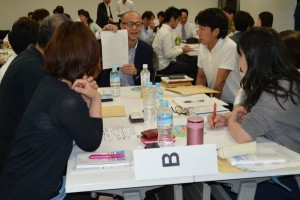 各グループごとに学びを共有する、写真奥は、講師の藤原慎太郎・トヨタ自動車業務品質改善部第1TQM室主査
