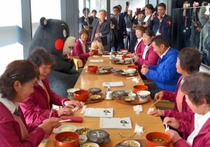 「熊本県水増集落 八天狗定食」の販売初日に来店したくまモンと水増集落の女性たち