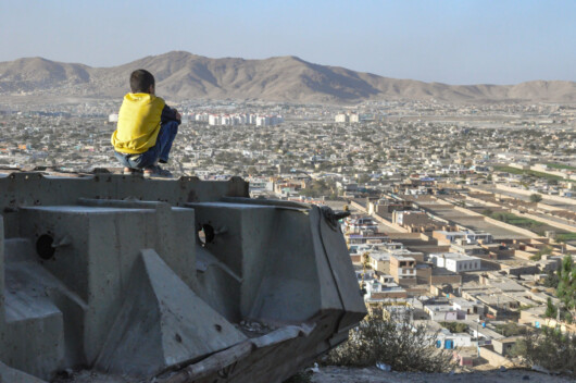 アフガニスタン・カブールの市で、破壊されたタンクに座る少年（2012年撮影）（画像はイメージ）